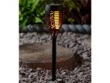 a close up of a light on a pole in a garden