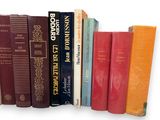 many books that are lined up together on a shelf