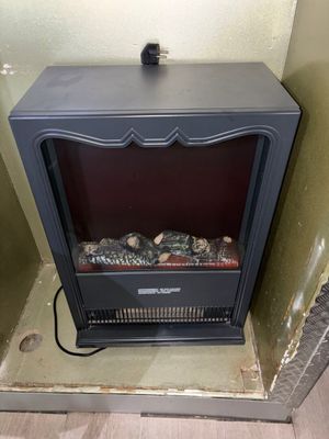 un petit poêle noir dans un coin de la pièce