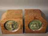 pair of wooden bookends with carved faces of a man and a woman