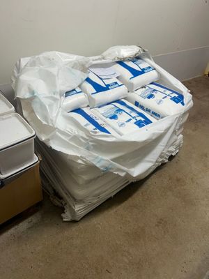 un tas de papier toilette par terre, à côté d'une poubelle