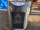 un distributeur d'eau posé par terre à côté d'une boîte