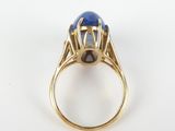 a close up of a gold ring with a blue stone