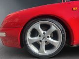 a close up of a red sports car parked in a parking lot