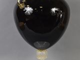 a large black vase with a gold decoration on it