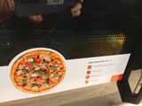 quelqu'un qui prend une photo d'une pizza avec son téléphone portable