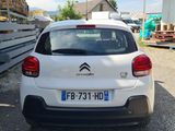 a small white car that is parked in a lot