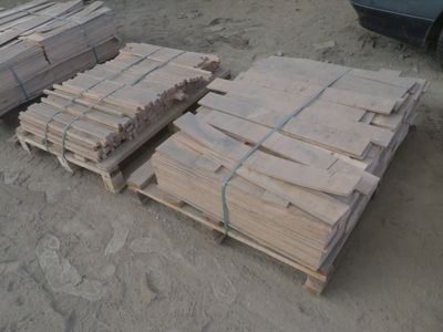 Plusieurs palettes de bois sont empilées sur une palette dans un parking