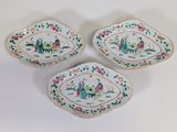 three pieces of porcelain dishes with floral designs on them on a white surface