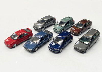 plusieurs petites voitures sont alignées sur une surface blanche