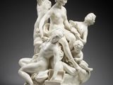 une sculpture blanche représentant un groupe de personnes assises sur une table