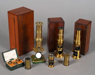 plusieurs types de microscopes et de boîtes posés sur une surface grise