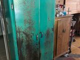 a green refrigerator in the corner of a room