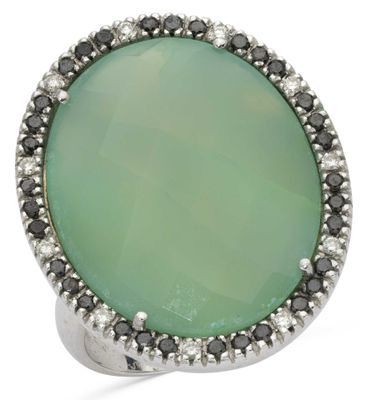 a close up of a ring with a green stone surrounded by black and white diamonds