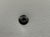 un gros plan d'un bouton sur une surface en cuir blanc
