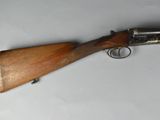 an old gun with a wooden handle on a white surface