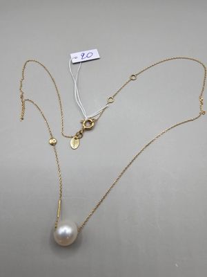 un collier de perles blanches et d'or sur fond blanc