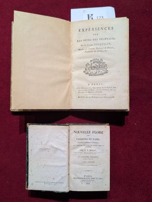 un livre ouvert posé sur une table à côté d'une feuille de papier