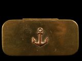 an image of a gold metal case with an anchor on it