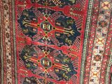 a rug on display in a store with a red chair