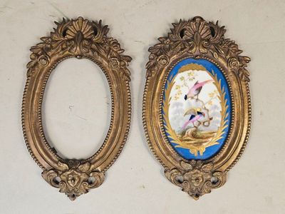 two gold frames with a picture of a bird and a bird in a nest