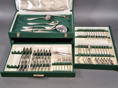 un coffret vert contenant de l'argenterie sur une table