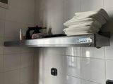 a stack of plates on a metal shelf in a kitchen