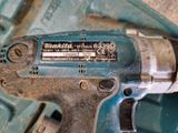 une perceuse posée sur une boîte bleue