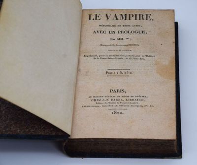 un livre ouvert sur une table blanche, avec une couverture noire