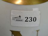 a close up of a white vase with a gold rim