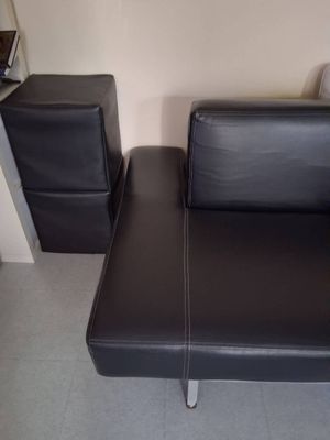 un canapé en cuir noir et un fauteuil dans un salon