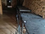 tables and chairs are lined up against a stone wall in a restaurant