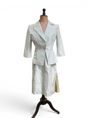 une robe et une veste sur un mannequin posé sur un support