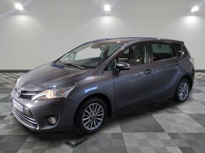Une Toyota Sienna grise est garée sur un sol en carrelage à damier.