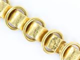 an image of a close up of a gold bracelet on a white surface
