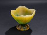 a small yellow flower shaped bowl on a black surface