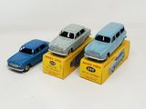 three toy cars sitting on top of boxes on a white surface