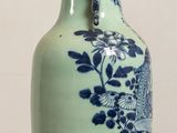 a blue and white vase sitting on a wooden table