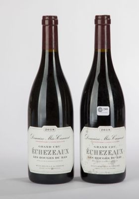 deux bouteilles de vin posées l'une à côté de l'autre sur une surface blanche