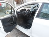 a white car with the door open and the driver ' s seat down