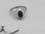 silver ring with a black stone and a cross on a white surface