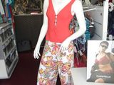 a mannequin wearing a red top and colorful pants in a store
