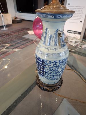 un vase bleu et blanc posé sur une table en verre