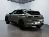 the rear end of a grey car in a white room