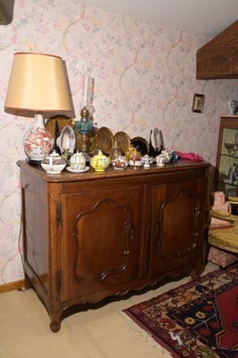 une armoire en bois sur laquelle sont posés un miroir et une lampe