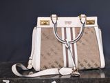 beige and white purse sitting on top of a black table