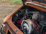 a brown car with an engine in the trunk of it