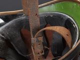 a black bucket with a green handle and a pair of shoes in it