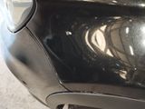 a close up of a car ' s front bumper with a black paint job