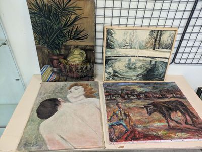 three paintings on a table with a plant in the background